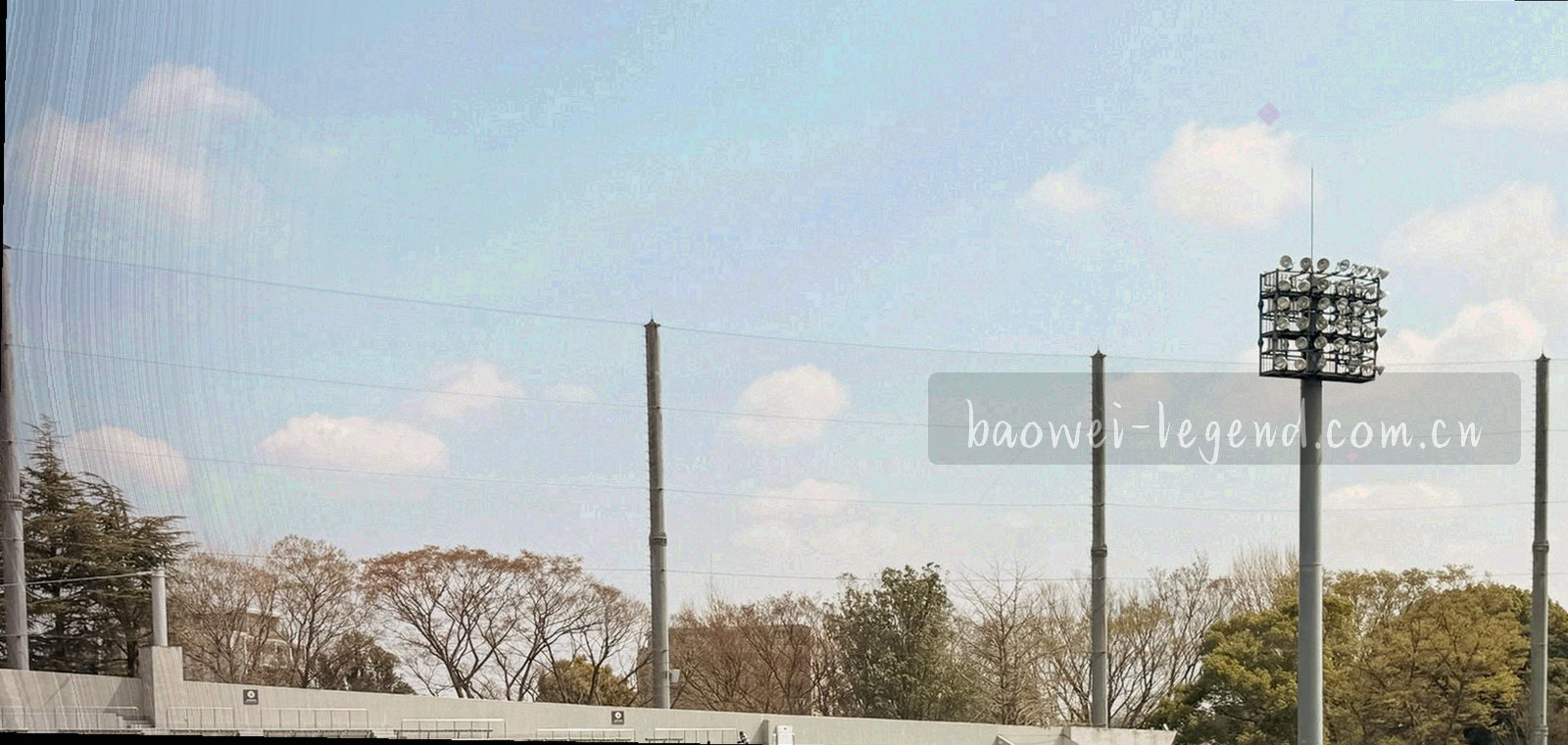 清晨草原地平线与远处球场轮廓，天空占据画面大半